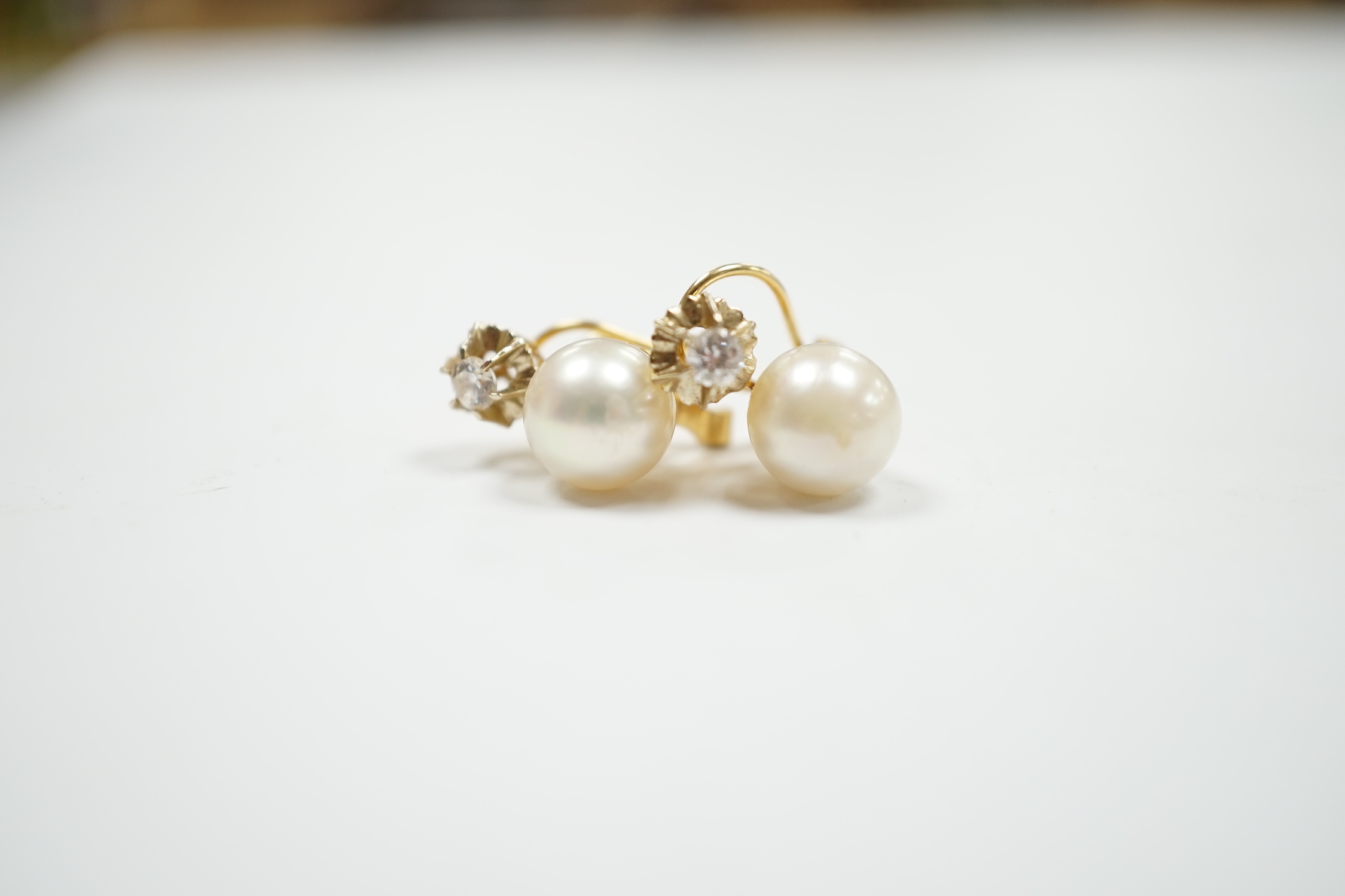 A pair of yellow metal, cultured pearl and simulated diamond set two stone earrings, 15mm, gross weight 4.3 grams.